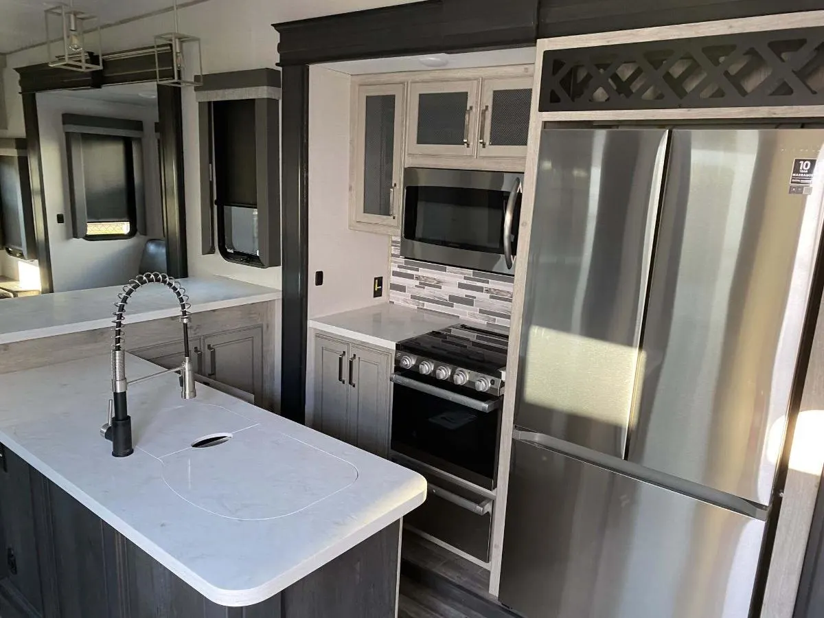 Kitchen with a gas range, fridge, oven, sink and cabinets.