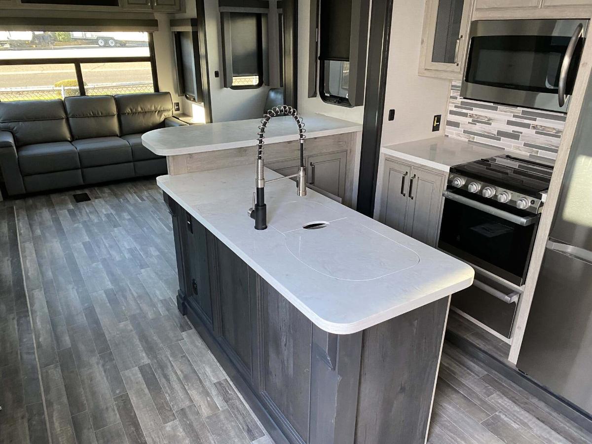 Kitchen with a gas range, fridge, oven, sink and cabinets.