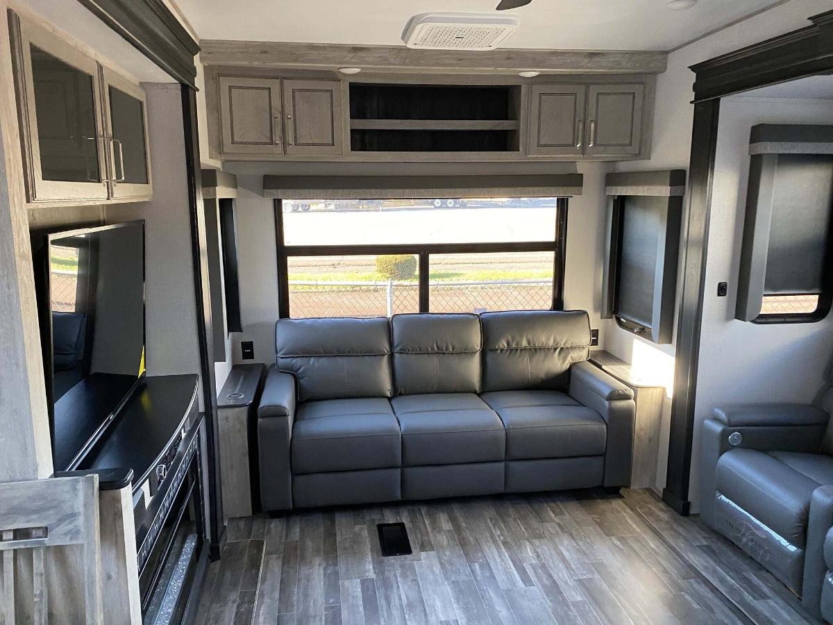 Living space with leather seats and overhead cabinets. 