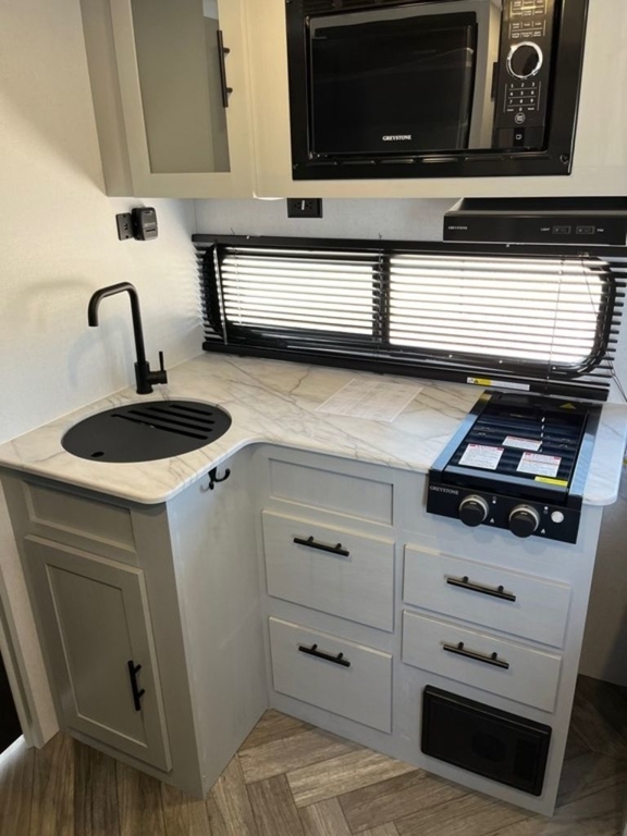 Kitchen with a gas range, oven, sink and cabinets.