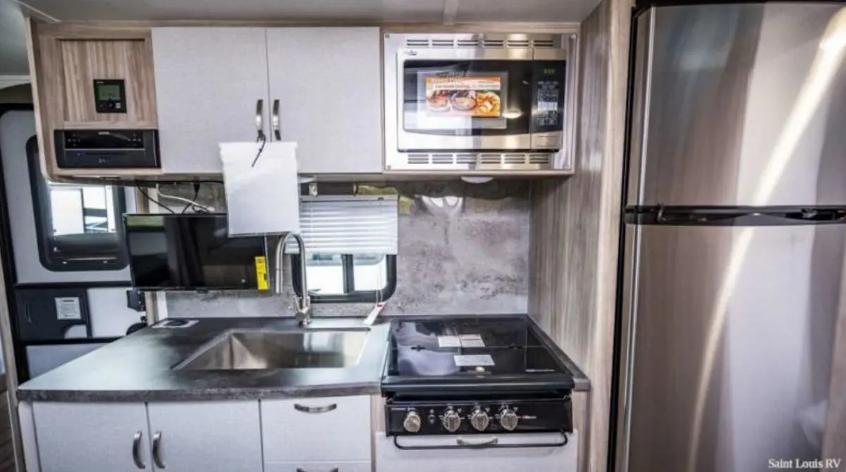 Kitchen with a gas range, fridge, oven, sink and cabinets.