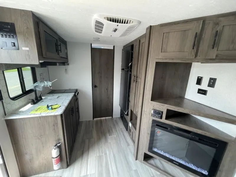 Interior view of the RV with a fireplace and a kitchen.