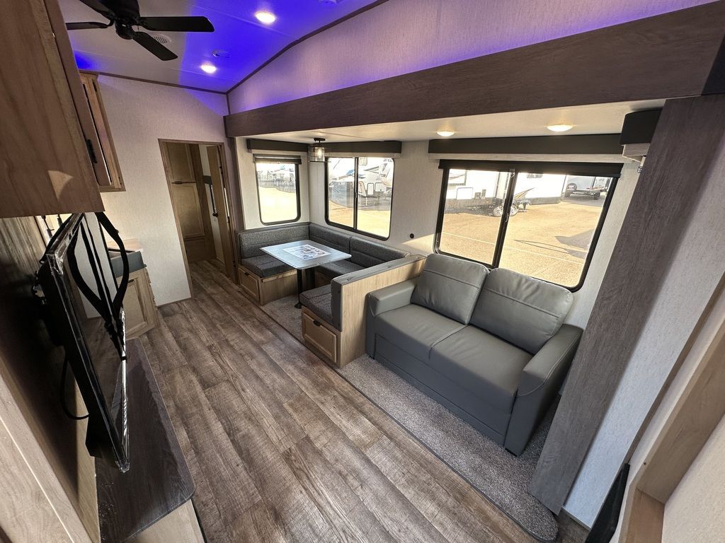 Interior view of the RV with a dinette and a living space.