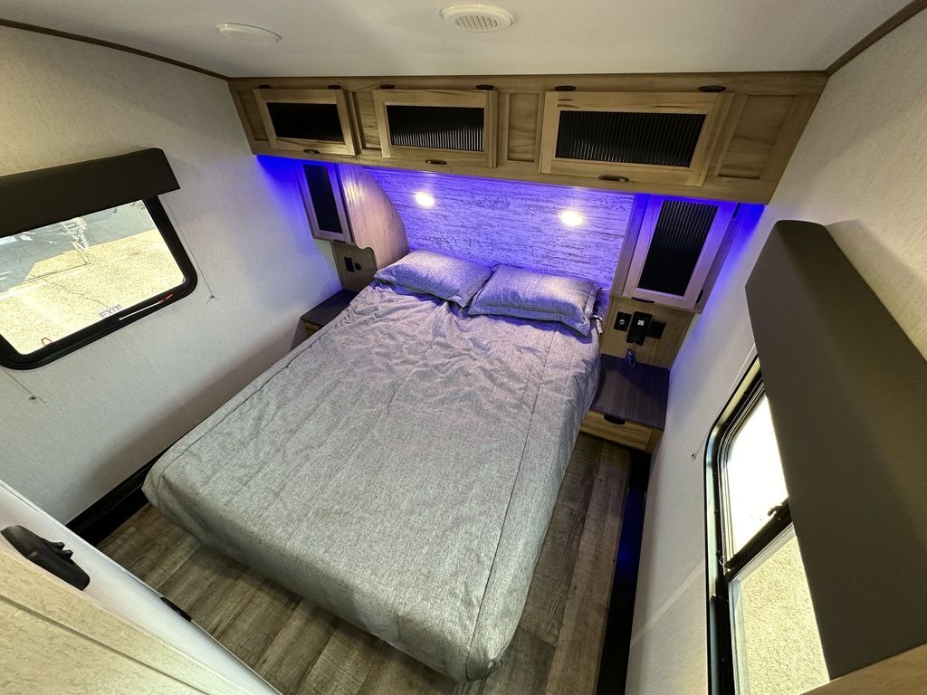 Bedroom with a queen size bed, overhead cabinets and shirt closets.