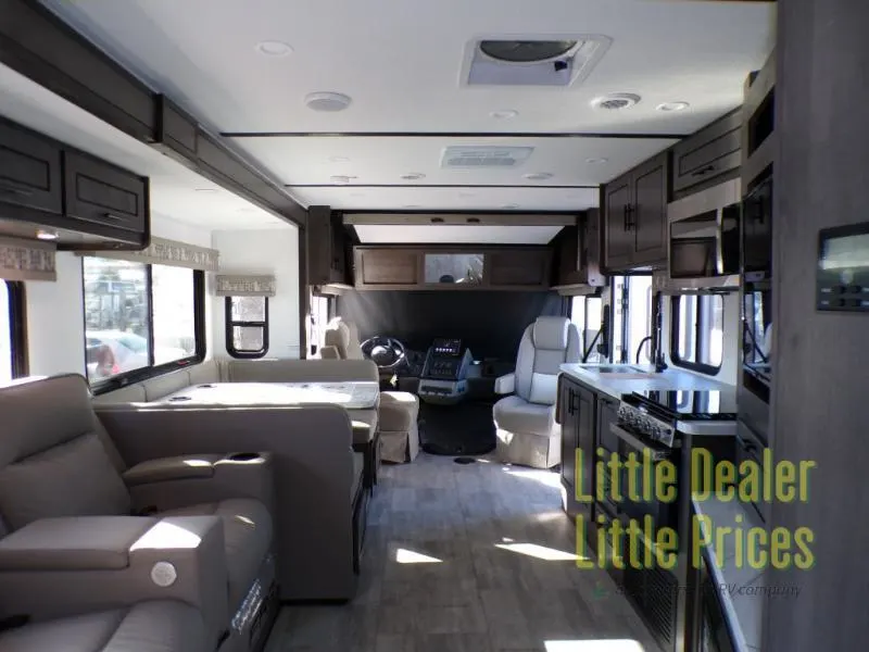 Interior view of the RV with a dinette, living space and a kitchen.