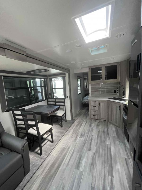 Interior view of the RV with a dinette, living space and a kitchen.