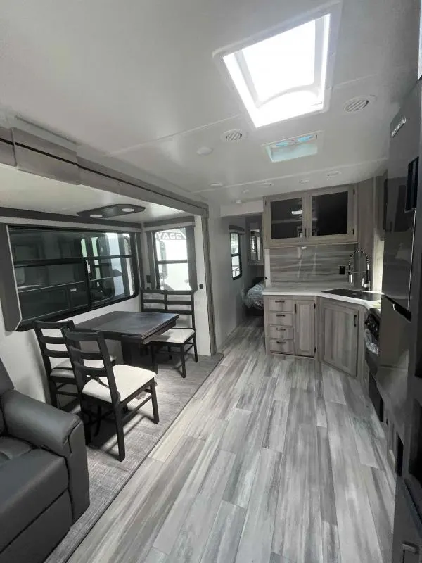 Interior view of the RV with a dinette, living space and a kitchen.