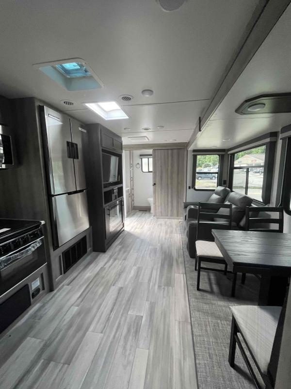 Interior view of the RV with a dinette, living space and a kitchen.