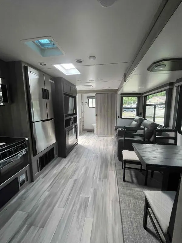 Interior view of the RV with a dinette, living space and a kitchen.