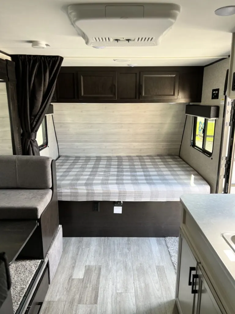 Bedroom with a queen size bed and overhead cabinets.