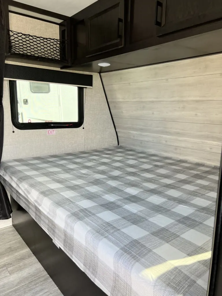 Bedroom with a queen size bed and overhead cabinets.