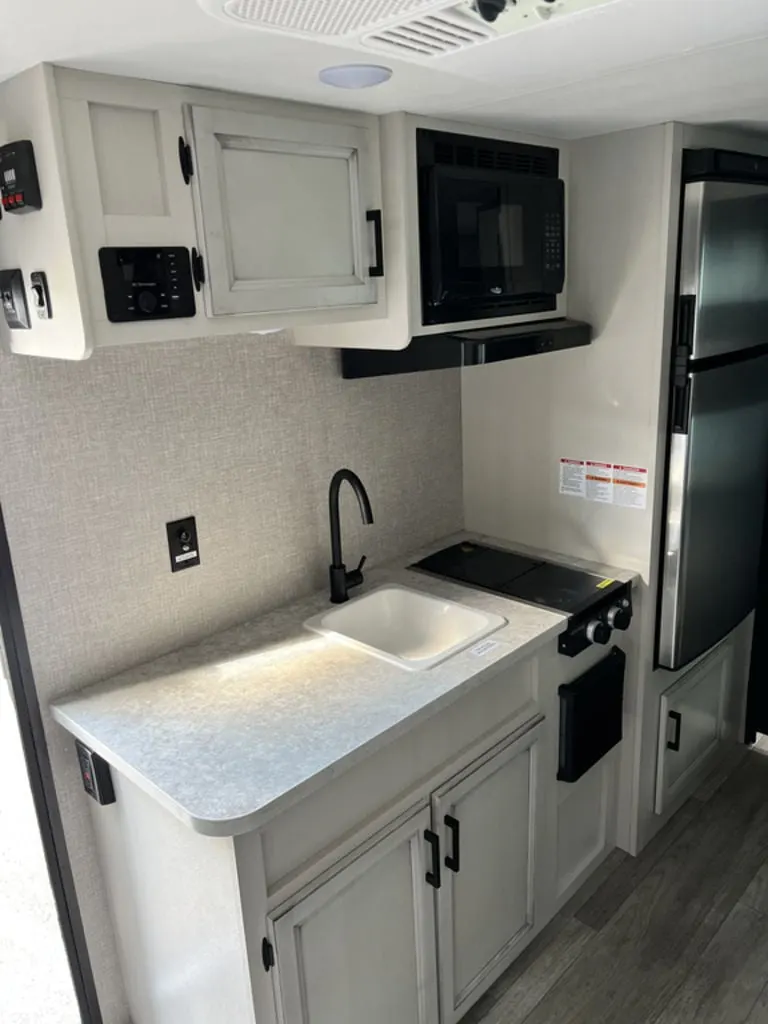 Kitchen with a gas range, fridge, oven, sink and cabinets.