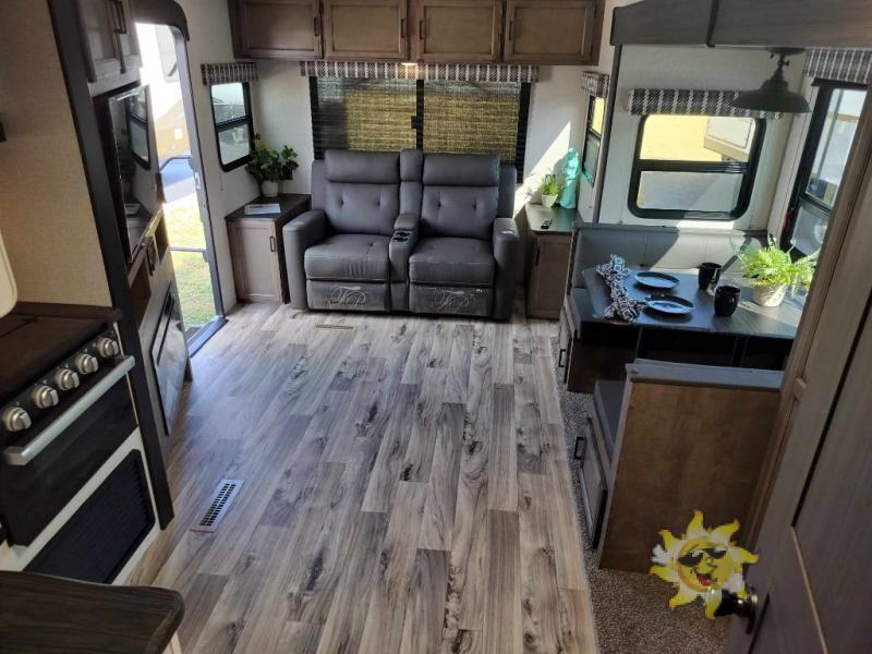 Interior view of the RV with a dinette, living space and a kitchen.