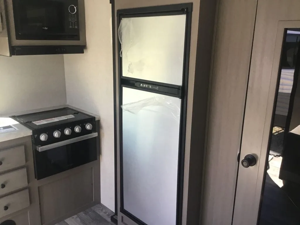 Kitchen with a gas range, fridge, oven, and drawers.