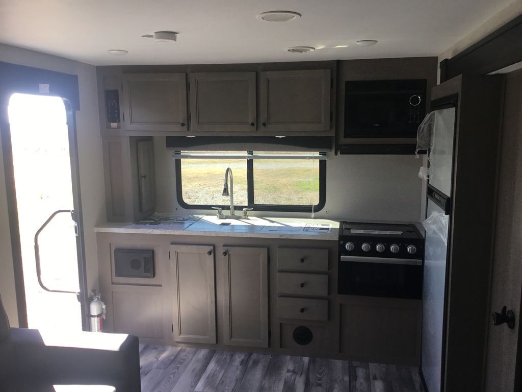 Kitchen with a gas range, fridge, oven, sink and cabinets.