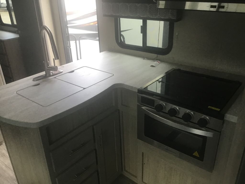 Kitchen with a gas range, sink and cabinets.