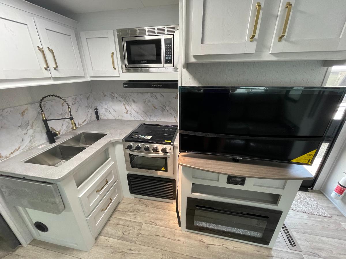 Kitchen with a gas range, oven, sink and cabinets.