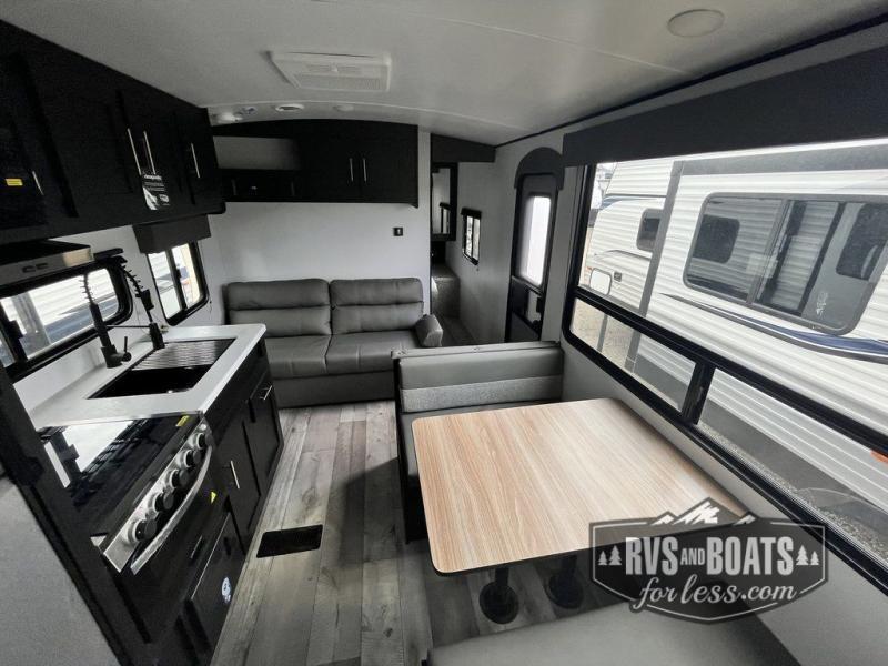 Interior view of the RV with a dinette, living space and a kitchen.