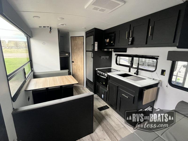 Interior view of the RV with a dinette, bedroom and a kitchen.