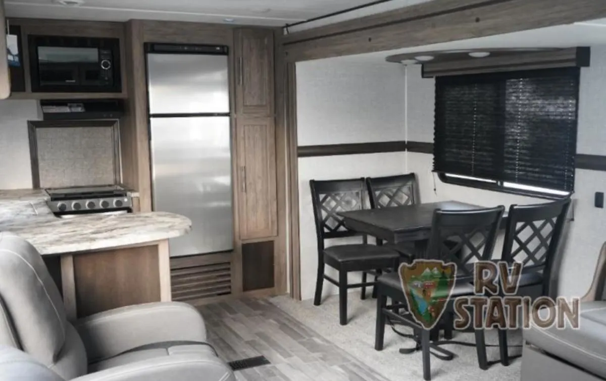 Interior view of the RV with a dinette, living space and a kitchen.