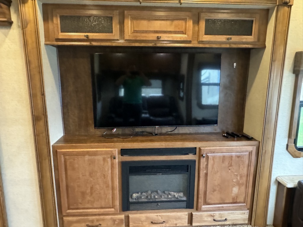 Entertainment center with a TV and a fireplace.