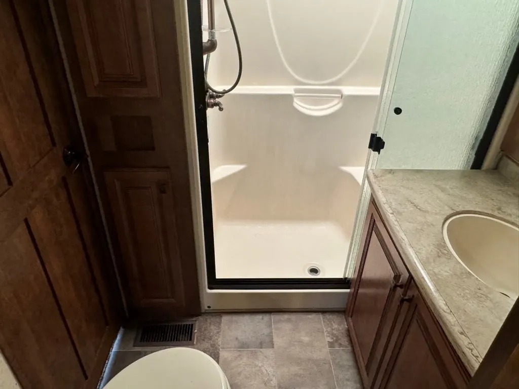 Bathroom with a sink, toilet and a walk-in shower.