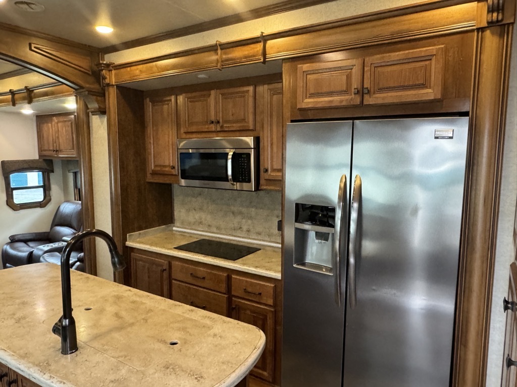 Kitchen with a fridge, oven, sink and cabinets.