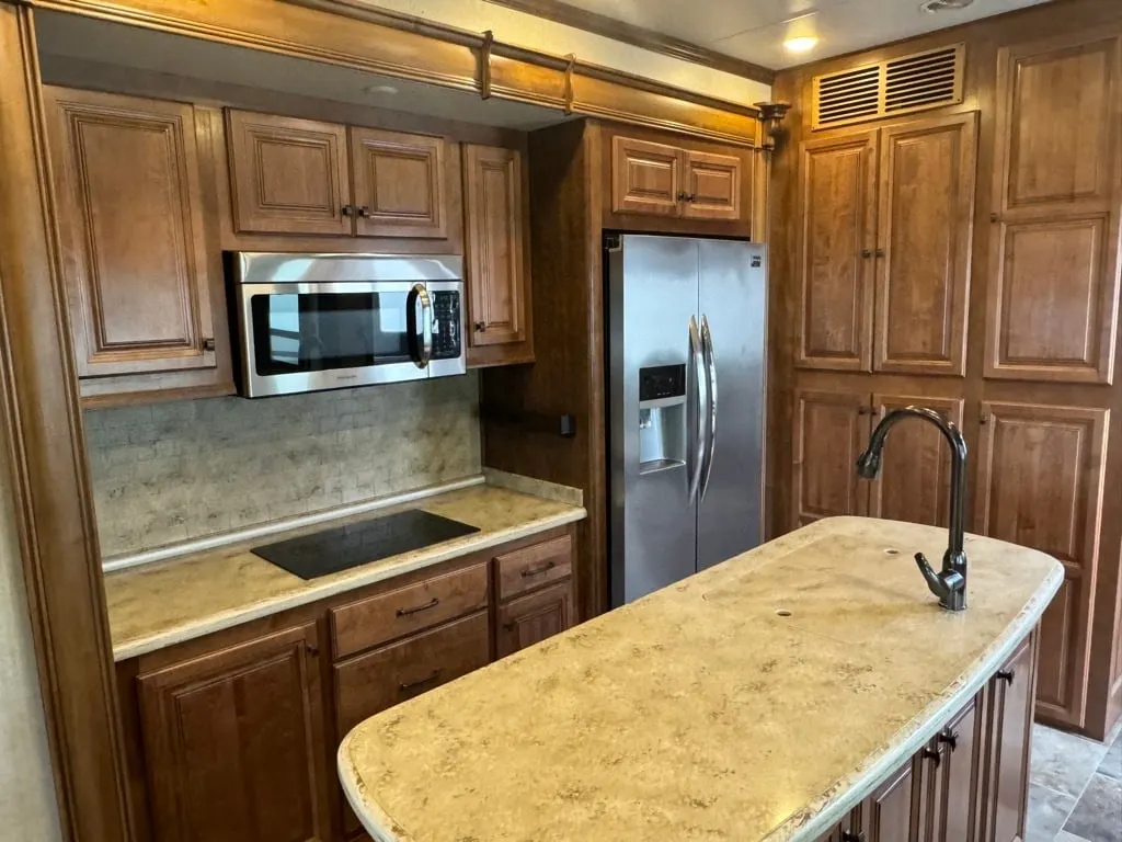 Kitchen with a fridge, oven, sink and cabinets.