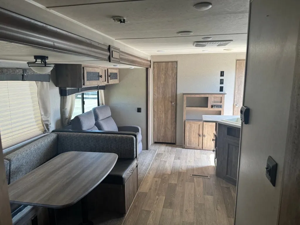 Interior view of the RV with a dinette, living space and a kitchen.