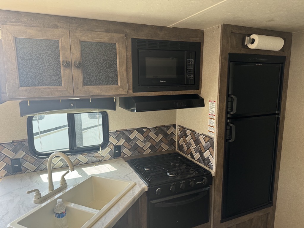 Kitchen with a gas range, fridge, oven, sink and cabinets.