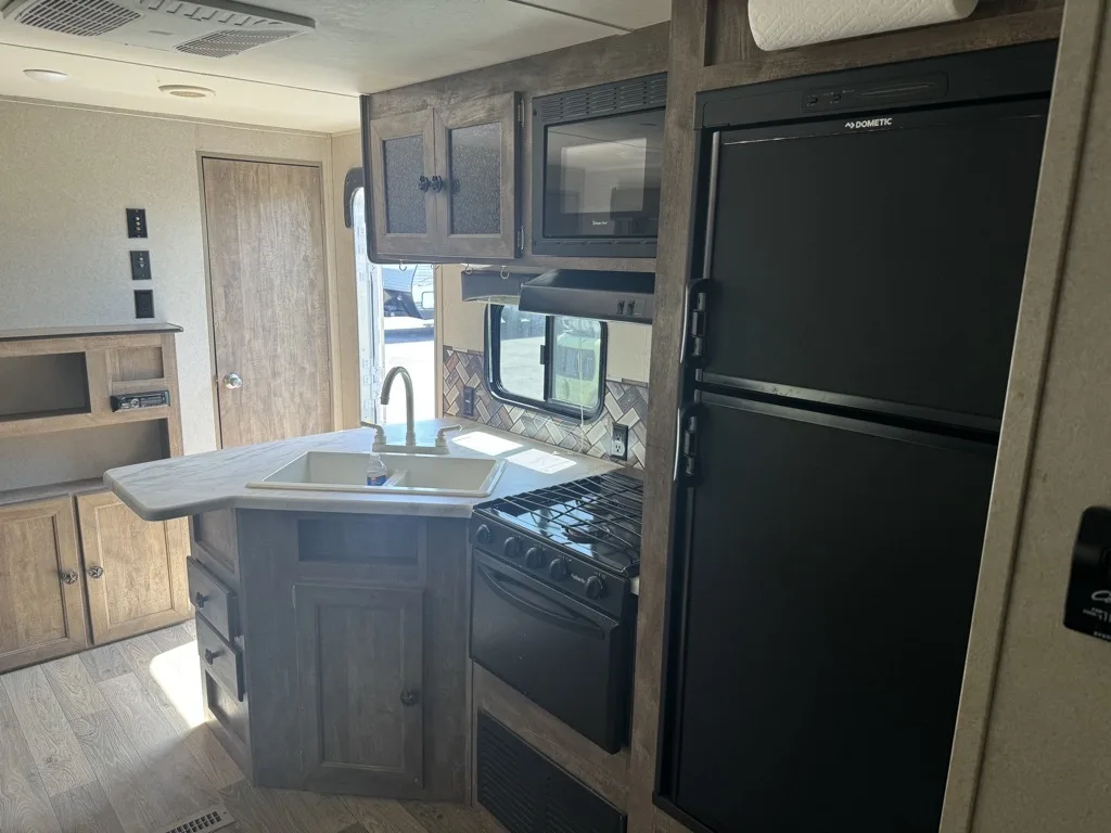 Kitchen with a gas range, fridge, oven, sink and cabinets.