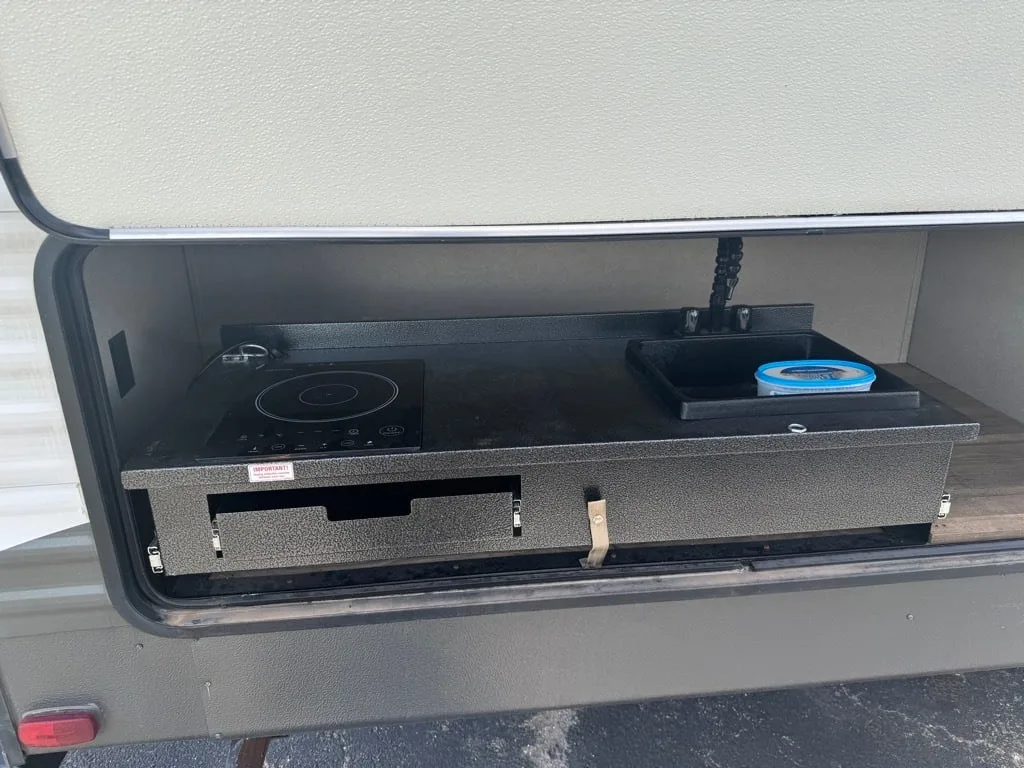 Outdoor kitchen with a gas griddle and a sink.