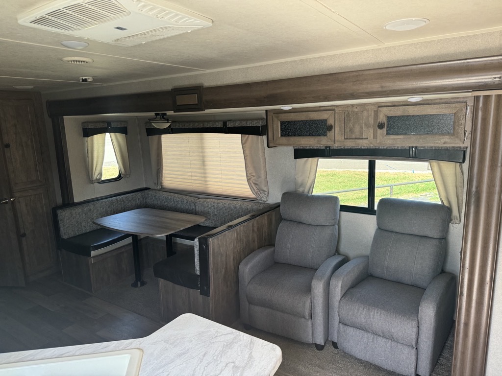 Interior view of the RV with a dinette and a living space.