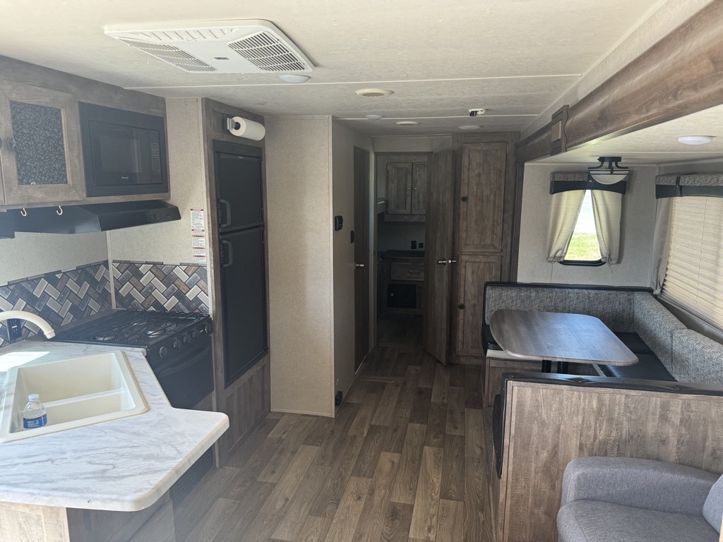 Interior view of the RV with a dinette, living space and a kitchen.