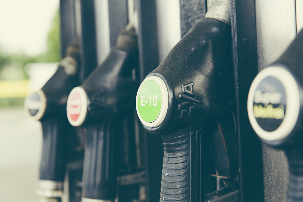 Close-up view of multiple gas pump nozzles, with the one marked "E-10" prominently in focus.