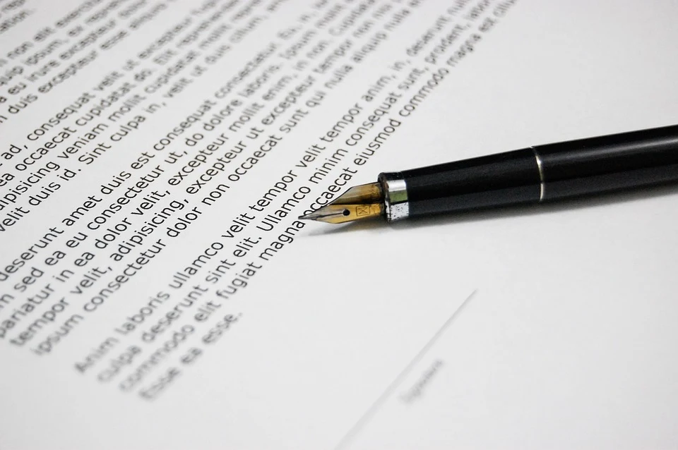 A close-up of a fountain pen resting on a printed document with text.