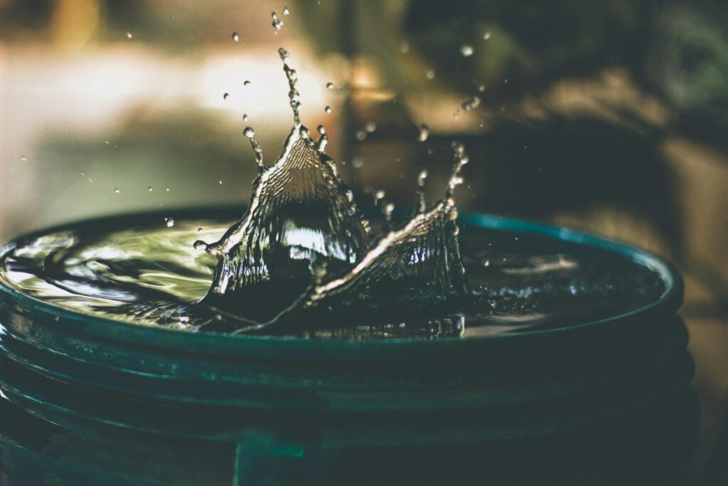 A close-up of water splashing in a circular basin, with droplets frozen in mid-air.