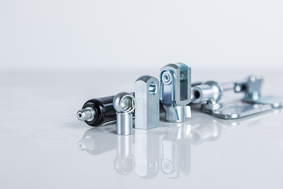 Close-up shot of various metal mechanical parts and components on a white surface.