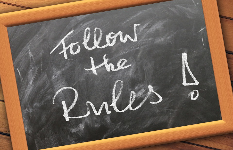 A chalkboard with the words "Follow the Rules!" written in white chalk.