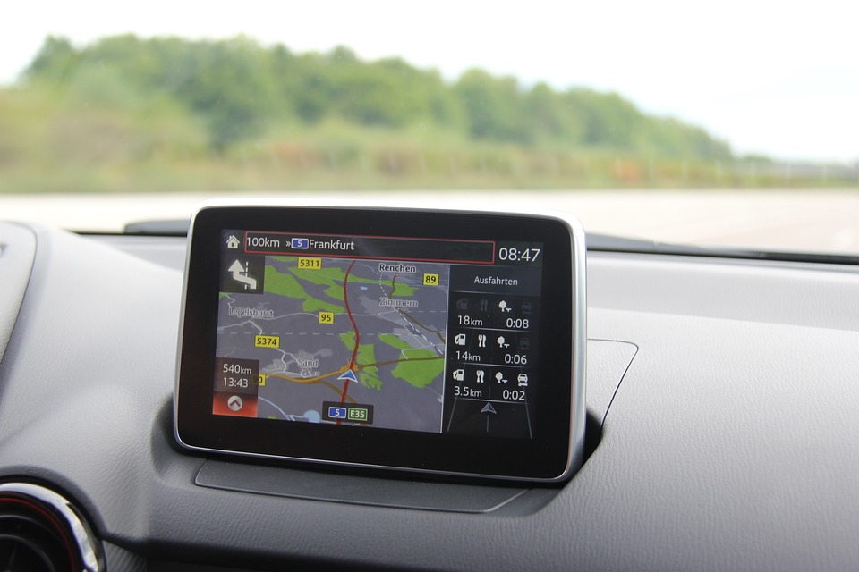 A car's GPS navigation screen showing a map with directions to Frankfurt.