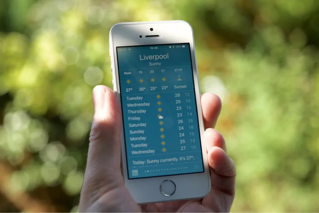 A close-up of a smartphone displaying a weather forecast for Liverpool.