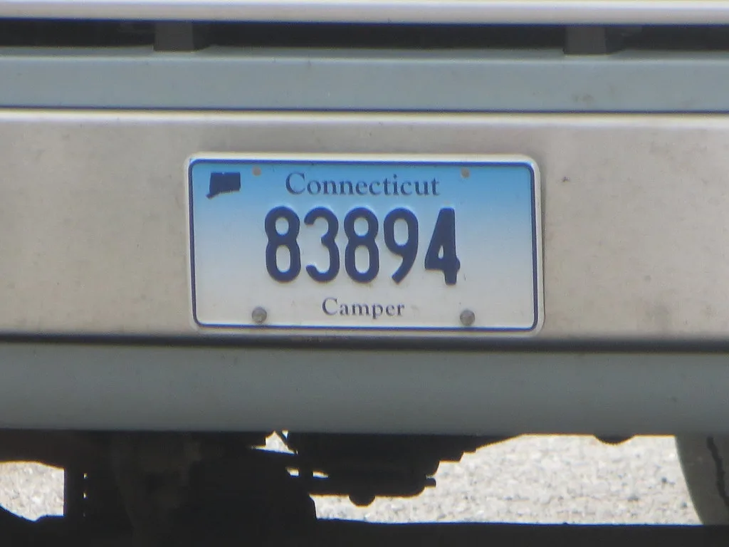 A close-up of a Connecticut camper license plate with the number 83894.