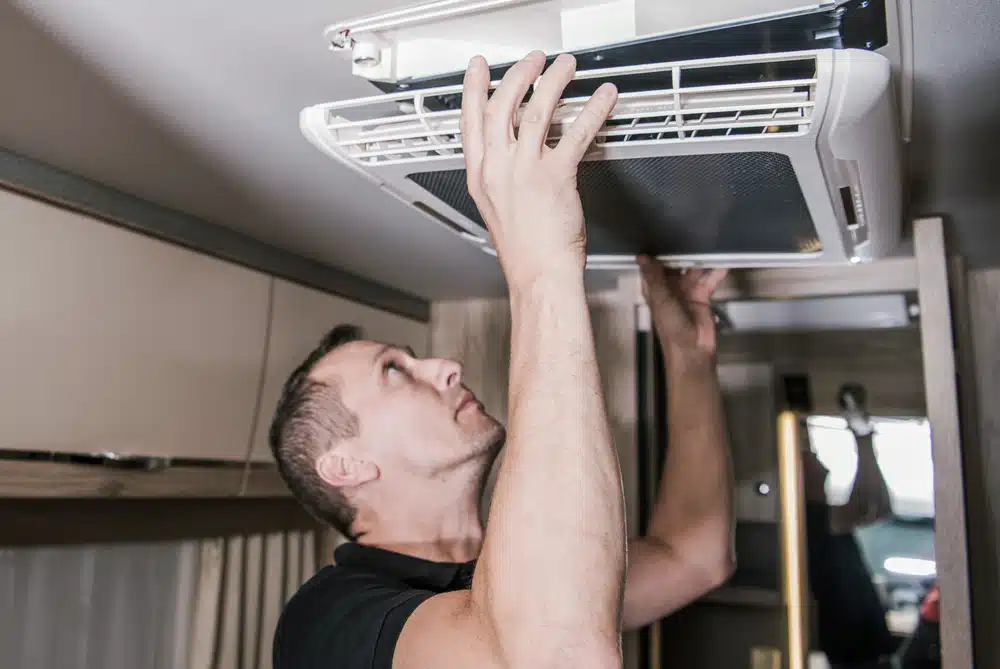 A man checking HVAC system in an RV